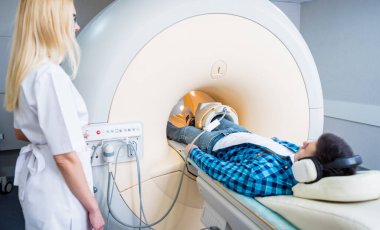 Radyoloji uzmanı hastayı MRI diz muayenesi için hazırlıyor.