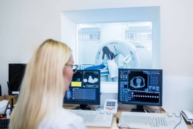 Hastanedeki bilgisayarlı tomografi kontrol odasında radyolog.