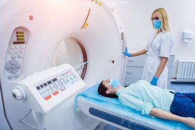 Radyolog, bilgisayarlı tomografi odasında bir kadın hasta ile birlikte.