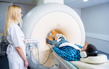 Radyoloji uzmanı hastayı MRI diz muayenesi için hazırlıyor.