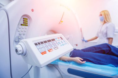 Radyolog, bilgisayarlı tomografi odasında bir kadın hasta ile birlikte.