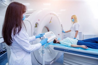 Radyolog, bilgisayarlı tomografi odasında bir kadın hasta ile birlikte.