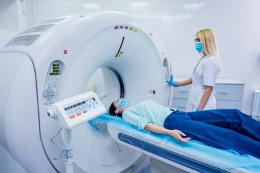 Radyolog, bilgisayarlı tomografi odasında bir kadın hasta ile birlikte.