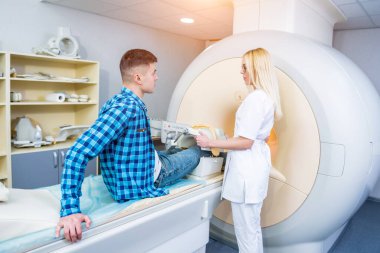 Radyoloji uzmanı hastayı MRI diz muayenesi için hazırlıyor.