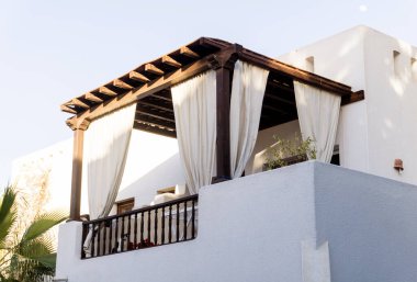 Tropikal bahçedeki en üst katın balkon ve çatılı manzarası.