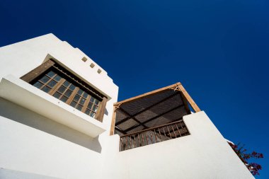 Tropikal bahçedeki en üst katın balkon ve çatılı manzarası.