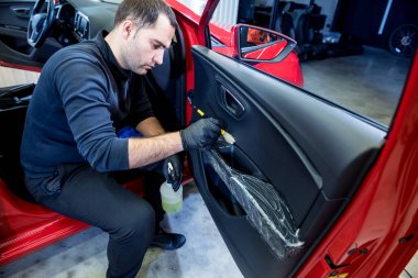 Araba servisi çalışanı iç mekanı özel fırçayla temizliyor