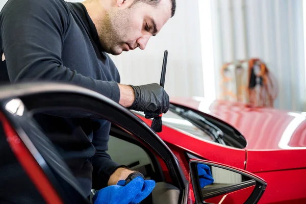 Araba servisi çalışanı iç mekanı özel fırçayla temizliyor