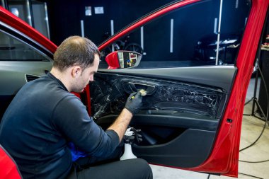 Araba servisi çalışanı iç mekanı özel fırçayla temizliyor