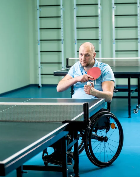 Дорослий інвалідний чоловік у навчанні на інвалідному візку перед грою в настільний теніс — стокове фото