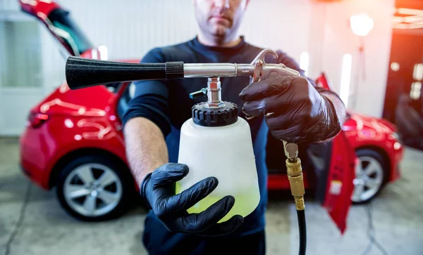 Ein Autoservice-Mitarbeiter reinigt den Innenraum mit einem speziellen Schaumgenerator — Stockfoto