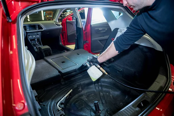 A car service worker cleans interiror with a special foam generator — Stock Photo, Image