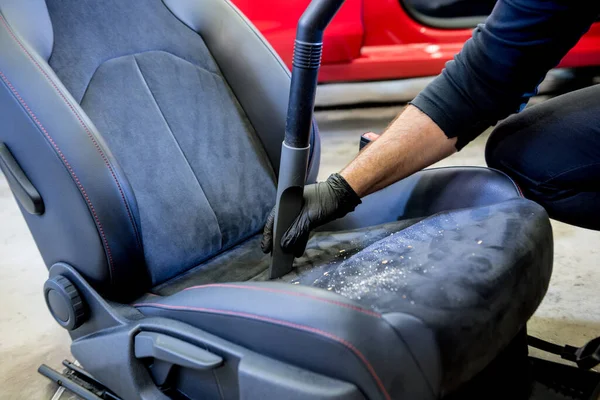 Auto service werknemer schoonmaken autostoel met stofzuiger. — Stockfoto