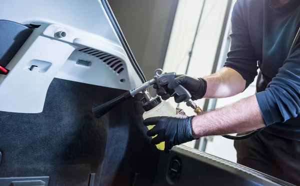 Un trabajador de servicios de automóviles limpia el interior con un generador de espuma especial —  Fotos de Stock