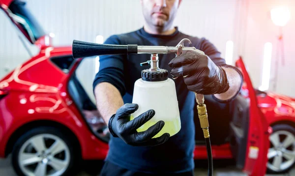 Un trabajador de servicios de automóviles limpia el interior con un generador de espuma especial —  Fotos de Stock