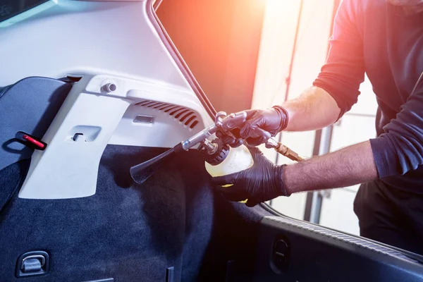 En bilservicearbetare rengör interiören med en speciell skumgenerator — Stockfoto