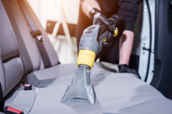 Premium Photo  Worker cleans car interior with vacuum cleaner