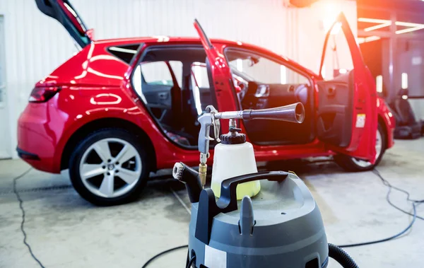 Um trabalhador de serviço de carro limpa o interior com um gerador de espuma especial — Fotografia de Stock
