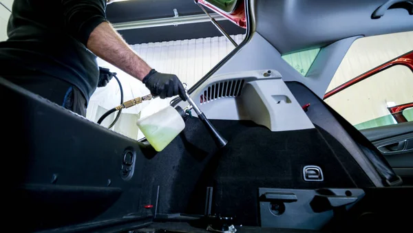 A car service worker cleans interiror with a special foam generator — Stock Photo, Image
