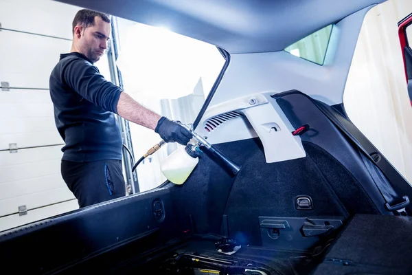 A car service worker cleans interiror with a special foam generator — Stock Photo, Image