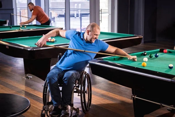 Hombre adulto con discapacidad en silla de ruedas jugar billar en el club —  Fotos de Stock