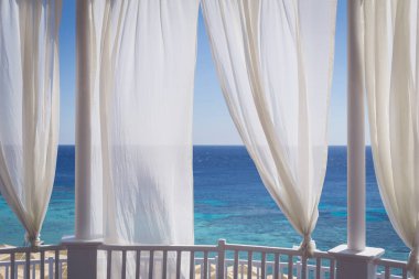 Kumsalda mavi denizli romantik bir çardak.