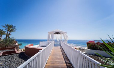 Kumsalda mavi denizli romantik bir çardak.