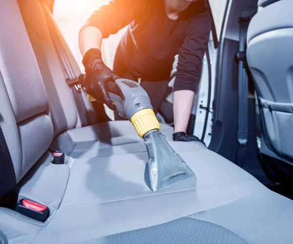 Werknemer reinigt auto interieur met stofzuiger — Stockfoto