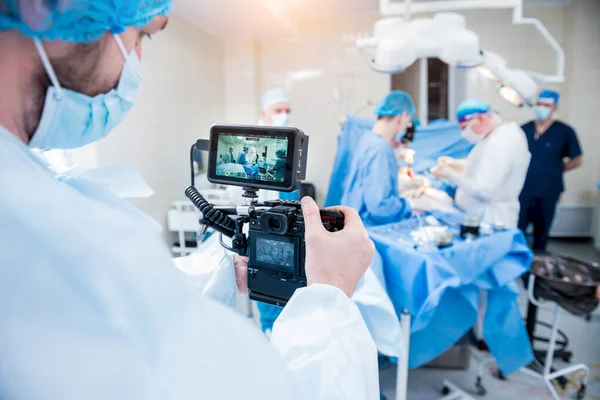 The videographer shoot the surgeon and assistants in the operating room with surgical equipment