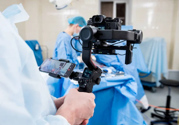 El videógrafo dispara al cirujano y a los asistentes en el quirófano con equipo quirúrgico —  Fotos de Stock