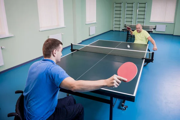 Hombres discapacitados adultos en silla de ruedas jugando al tenis de mesa — Foto de Stock