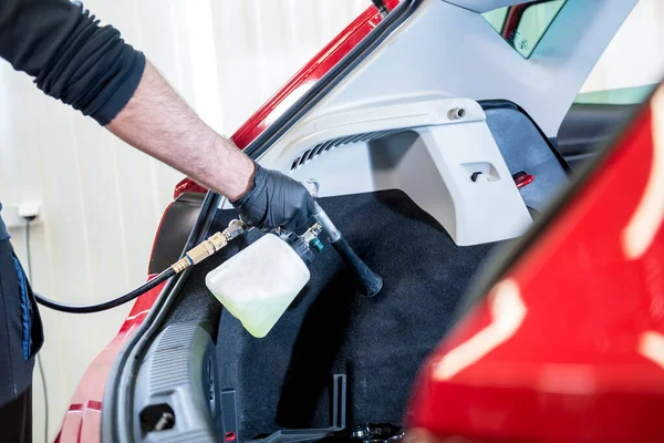 Un trabajador de servicios de automóviles limpia el interior con un generador de espuma especial —  Fotos de Stock