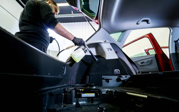 A car service worker cleans interiror with a special foam generator — Stock Photo, Image