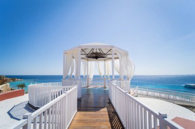 Kumsalda mavi denizli romantik bir çardak.