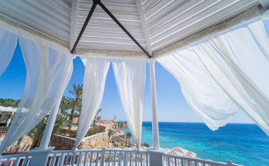 Kumsalda mavi denizli romantik bir çardak.