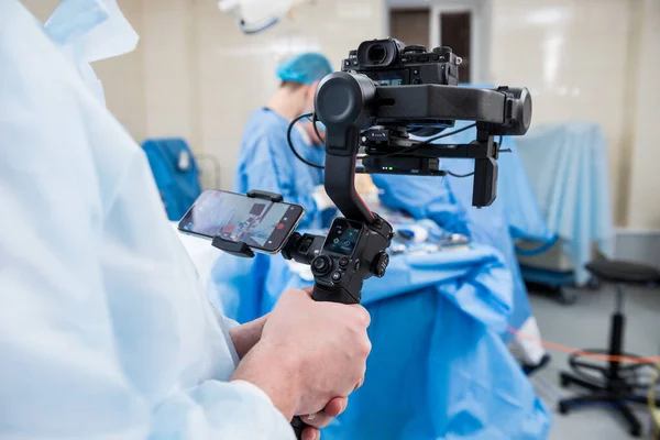 摄影师在手术室用外科设备向外科医生和助手开枪 — 图库照片