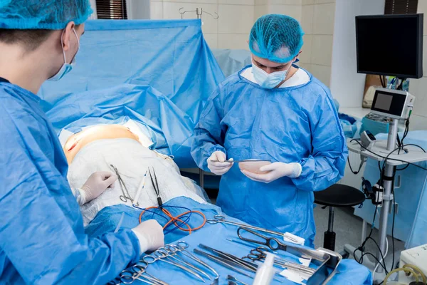 Aumento da mama sob a orientação da equipe de cirurgiões na sala cirúrgica. — Fotografia de Stock