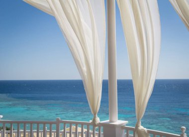 Kumsalda mavi denizli romantik bir çardak.