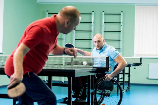 Behinderter Mann im Rollstuhl spielt mit seinem Trainer Tischtennis — Stockfoto