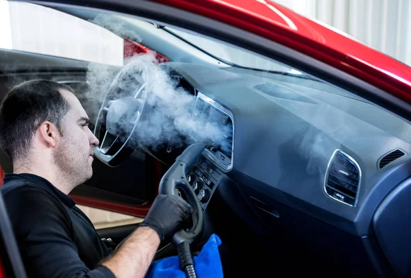 Trabajador de servicio de coches limpia el interior con un limpiador de vapor —  Fotos de Stock