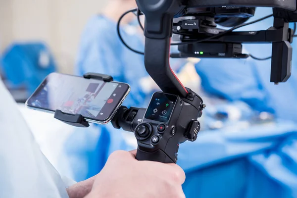 摄影师在手术室用外科设备向外科医生和助手开枪 — 图库照片