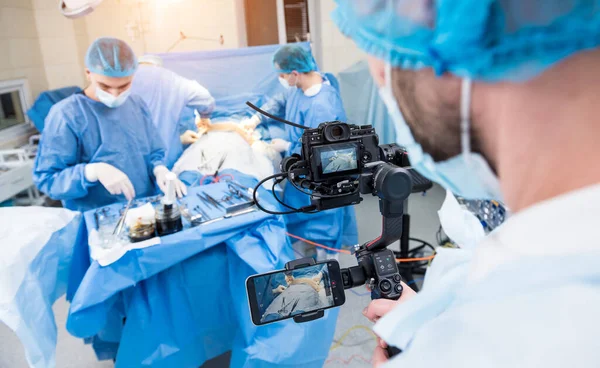 The videographer shoot the surgeon and assistants in the operating room with surgical equipment