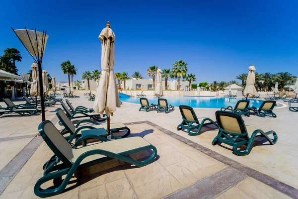 Espreguiçadeiras junto à piscina dos hotéis — Fotografia de Stock
