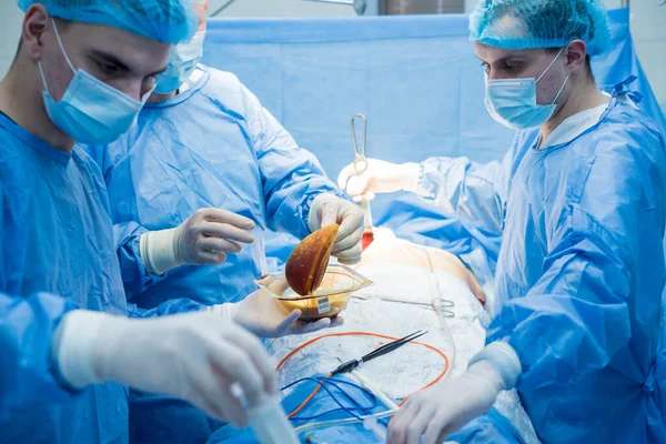 Breast augmentation under the guidance surgeons team in surgical operating room. — Stock Photo, Image