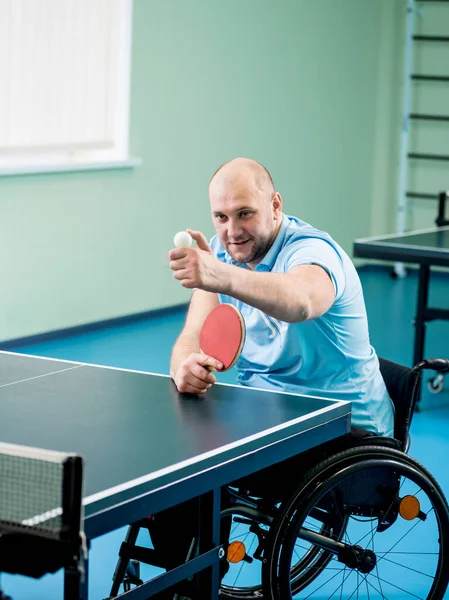 Adult disabled man in a wheelchair training before play at table tennis — Stock Photo, Image