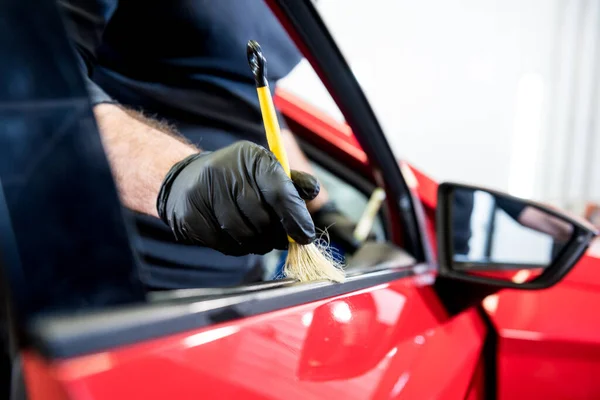 Operaio di servizio auto pulisce interiror con spazzola speciale — Foto Stock