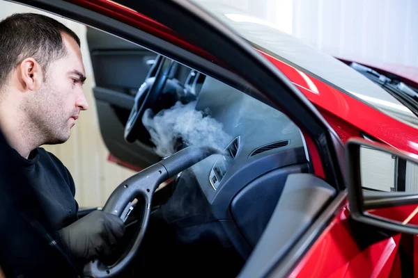 Trabajador de servicio de coches limpia el interior con un limpiador de vapor —  Fotos de Stock