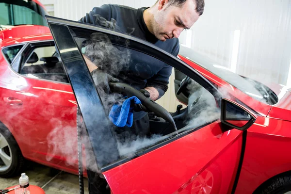 Autoservice-Mitarbeiter säubert Innenraum mit Dampfreiniger — Stockfoto