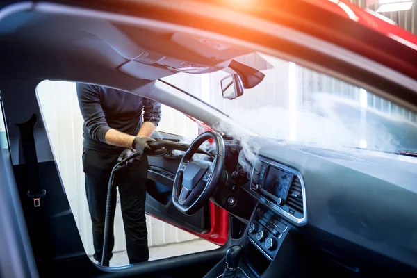 Trabajador de servicio de coches limpia el interior con un limpiador de vapor —  Fotos de Stock