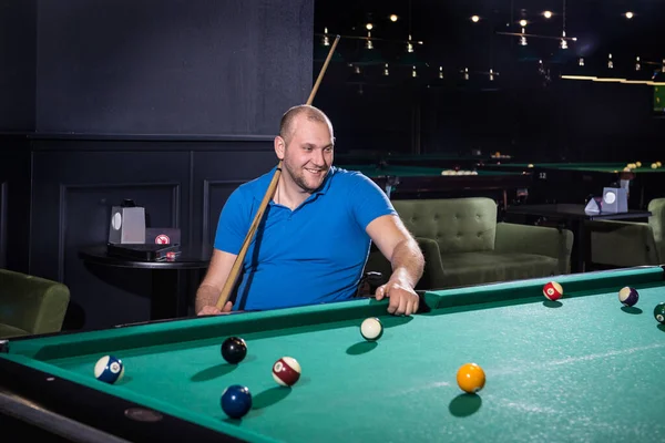 Adult man with disability in a wheelchair play billiards in the club